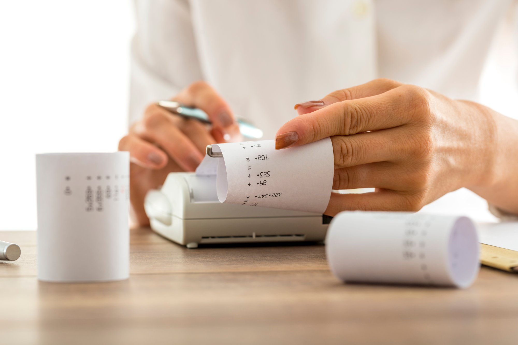 woman-doing-calculations-adding-machine-calculator-pulling-off-reams-paper-with-printed-figures-totals-conceptual-accounting-bookkeeping-close-up-her-hands woman-doing-calculations-adding-machine-calculator-pulling-off-reams-paper-with-printed-figures-totals-conceptual-accounting-bookkeeping-close-up-her-hands
